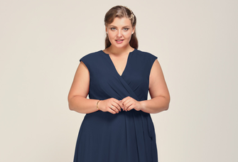 A model wears a navy blue wrap dress with a V-neckline.