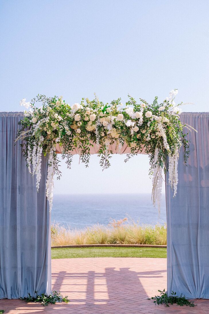 Ceremony Arch With Blue Fabric and Hanging Flowers