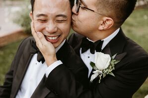 Two Grooms in Matching Classic Tuxedos and White Boutonnieres With Greenery