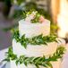The Gage Hotel baked Jesse and Desha's classic triple-tier white wedding cake. The couple chose to surround the tiers in greenery for a natural, earthy look.