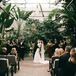 Bride and Groom Share First Kiss at Ceremony in Industrial Greenhouse Garden, Tropical and Greenery