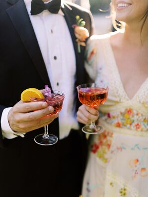 Wedding Guests in Formal Attire Holding Red Cocktails With Flowers and Citrus