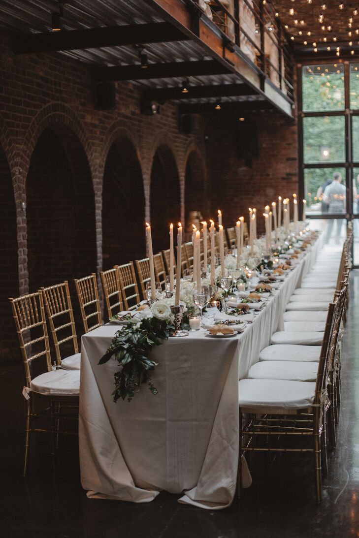 At the reception, long banquet tables were topped with crisp white linens, a long lemon-leaf and eucalyptus garland, and tall white candles.
