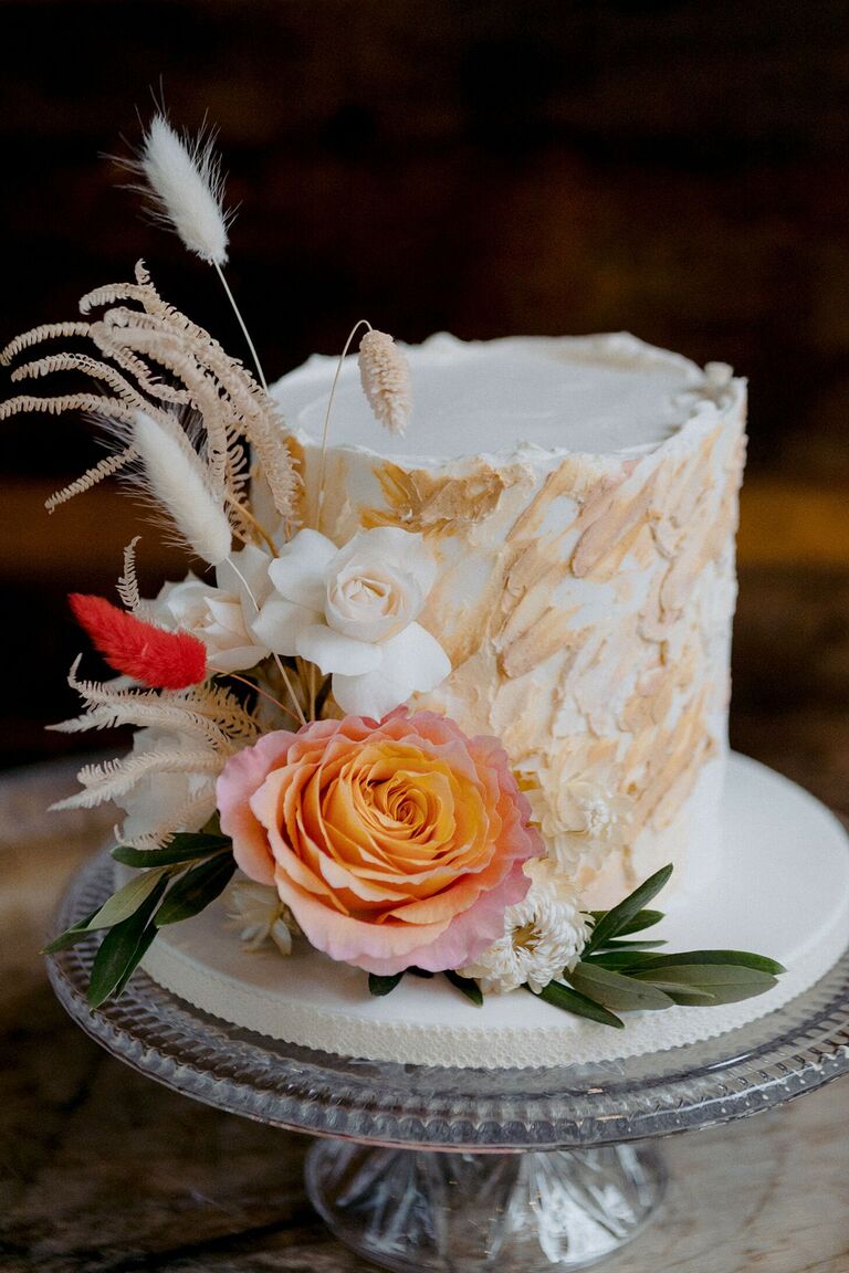 Rustic single-tier wedding cake decorated with dried elements