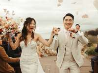 The newlyweds exit their beachside ceremony as their loved ones look on. 