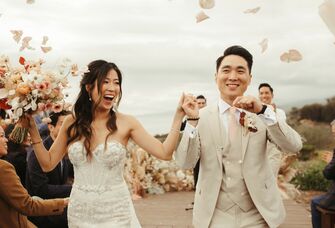 The newlyweds exit their beachside ceremony as their loved ones look on. 