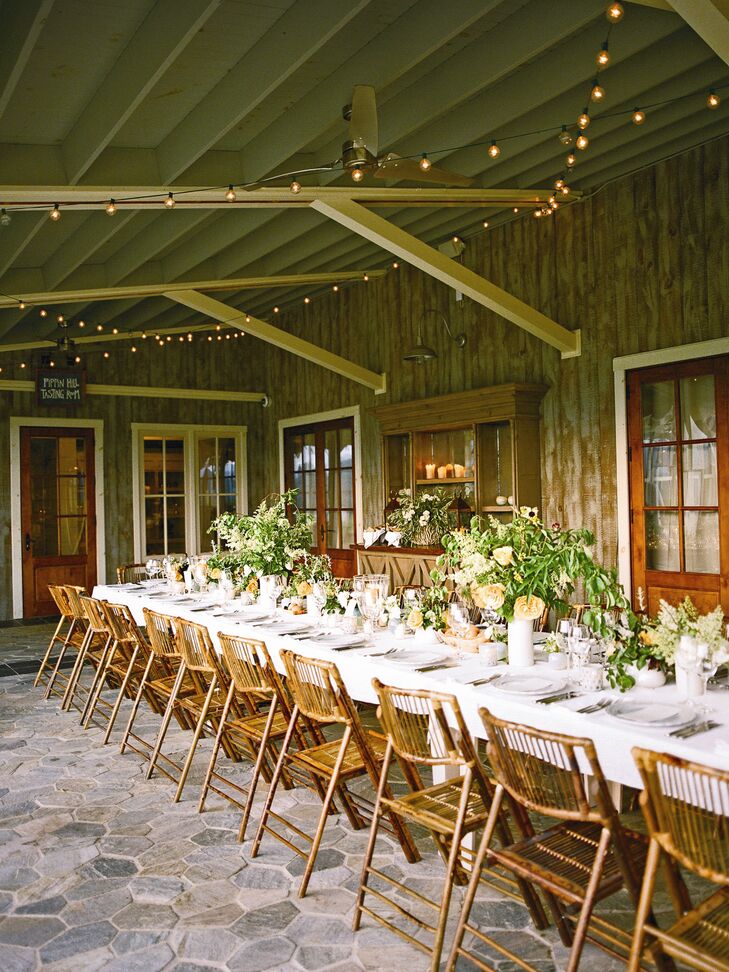 A guest list of 80 meant the couple could seat everyone at a single 80-foot wooden table on the veranda of Pippin Hill's Tasting Room. Bistro lights glowed above the whitewash table topped with white linens, trays of peaches and centerpieces of garden roses, green viburnum berries and herbs.