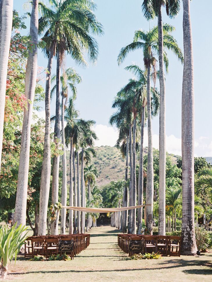 Two looming rows of royal palm trees naturally created the perfect aisle. The couple exchanged vows underneath a burlap canopy.