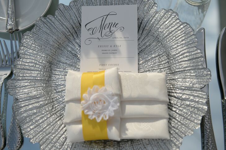 Each guest's place setting consisted of silver chargers,  an elegant menu card and a folded napkin tied with a bright yellow ribbon that matched the bridesmaids bouquets.