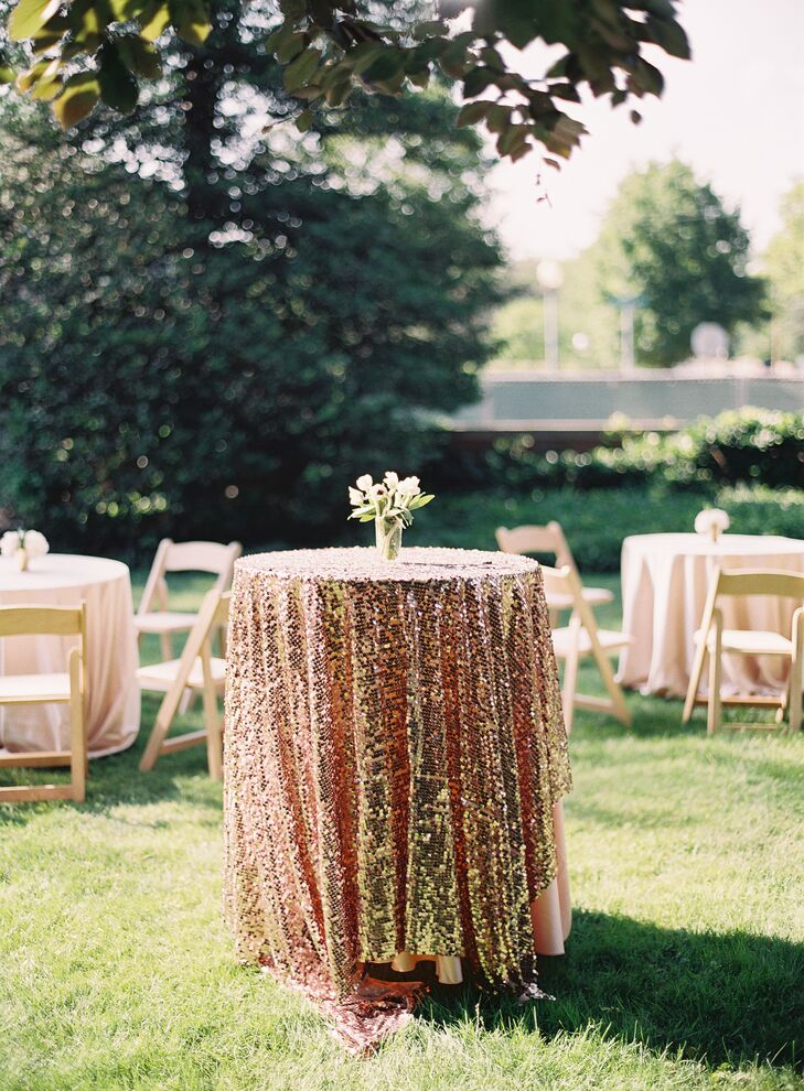 The cocktail hour had a more literal depiction of their literary inspiration. Similar to the glitzy days of “The Great Gatsby,” each cocktail table on the Cap and Gown Club in Princeton, New Jersey, lawn had a shimmering gold sequin linen. Low white tulip and other floral centerpieces gave them a more modern touch.