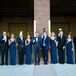 The groomsmen wore black suits, while the grooms wore navy blue to match the groomsmaid dresses. The women wore matching full-length, sleeveless gowns by Vera Wang accessorized with Givenchy jewelry.