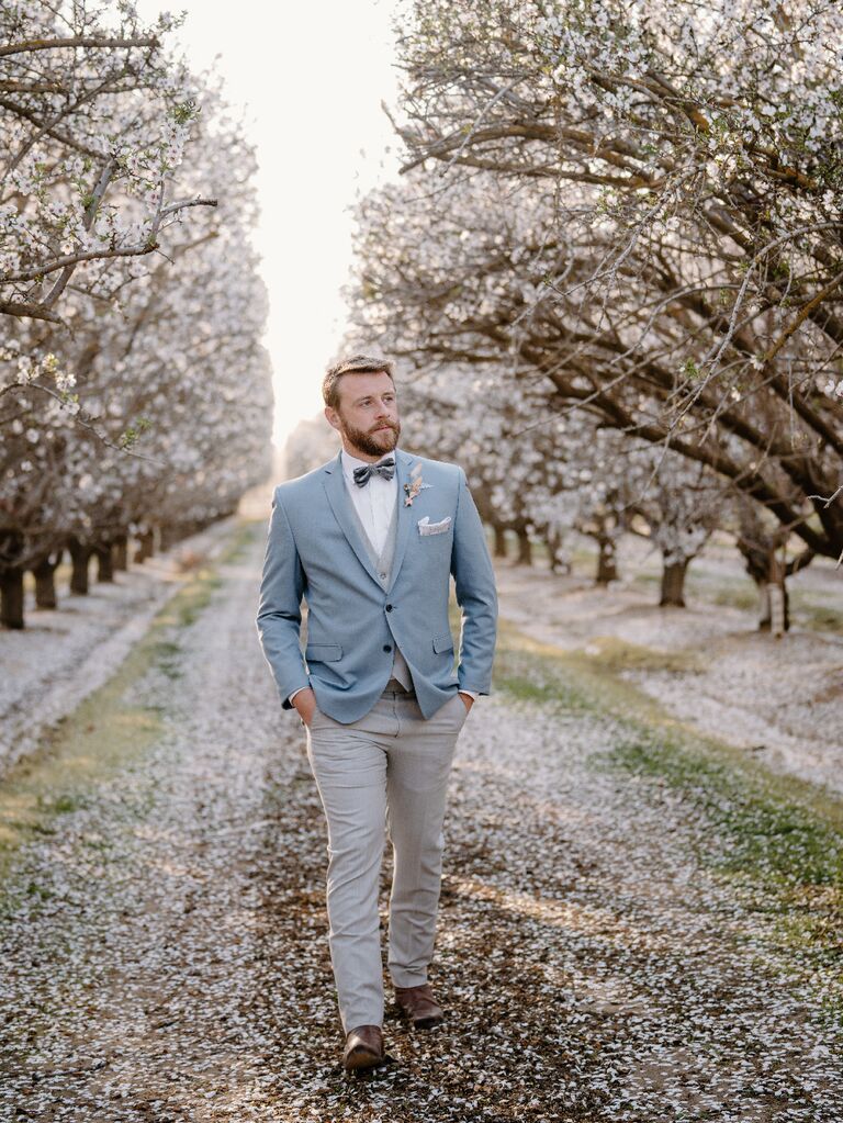 Groom wearing light blue suit at outdoor celestial wedding