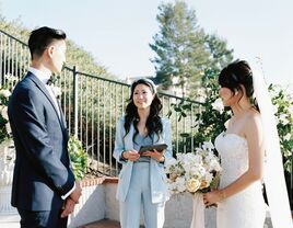 bride and groom stand outside at wedding ceremony with officiant