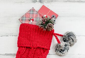 red knit christmas stocking for wife with wrapped gifts