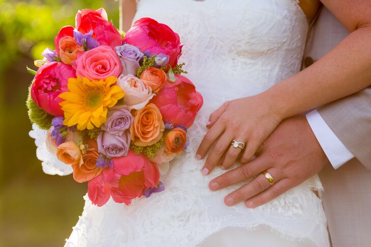 Katie carried yellow daisies; pink peonies; orange ranunculus and pink, orange and purple roses in her bouquet.