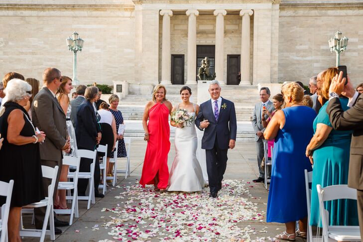Jackie walked arm in arm with her parents down the aisle toward the front, where Bryan awaited her arrival for the ceremony. Since the architecture of the museum surrounded the space, little decor beyond the rose-covered aisle had to be added.