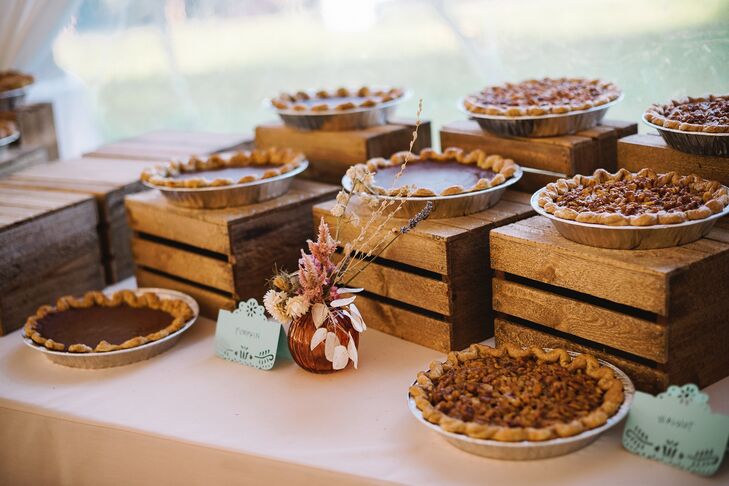 An autumnal dessert table at a fall wedding on the California Coast featuring different flavors of pie, such as pumpkin and pecan.