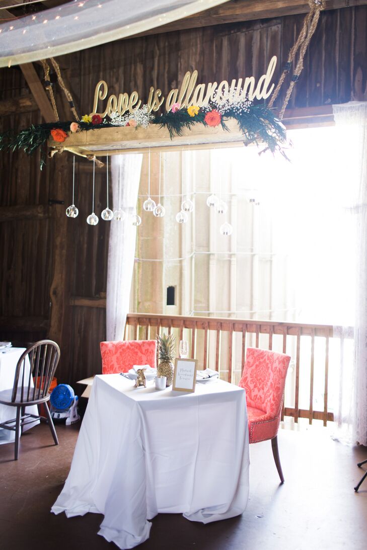 A large, handmade planter that read "love is all around" hung high above the couple's sweetheart table. "My mom and stepfather made it using flowers and floating candles," Molly says. "It really added a wow factor, since you noticed it when you walked into the barn."