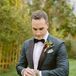 Groom in Deep, Structured Green Tuxedo Jacket With Black Trim, Fall Boutonniere