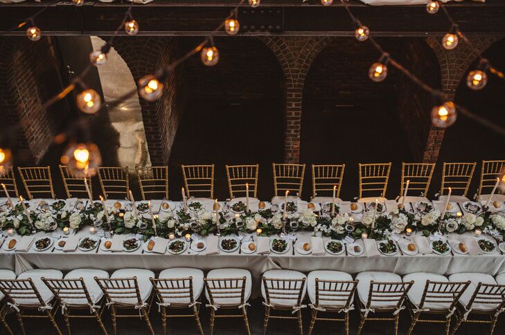 Long banquet tables were topped with crisp white linens, a lemon-leaf and eucalyptus garland, and tall white candles.