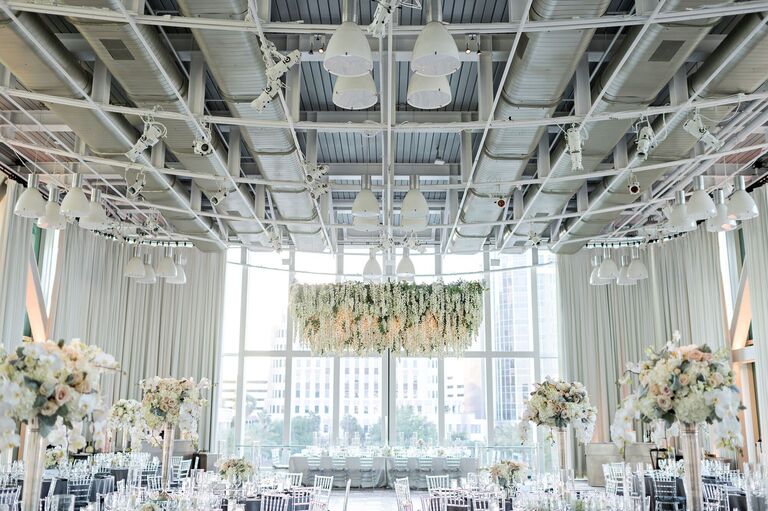 All-white reception decor with white floral chandelier