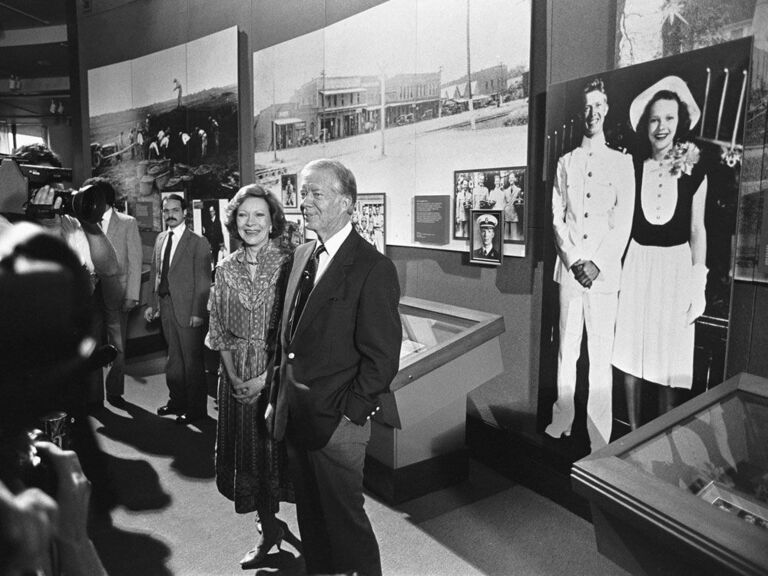 Rosalyn and Jimmy Carter standing in front of their wedding portrait