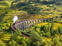 Glenfinnan Railway Viaduct in Scotland with the Jacobite steam train passing over