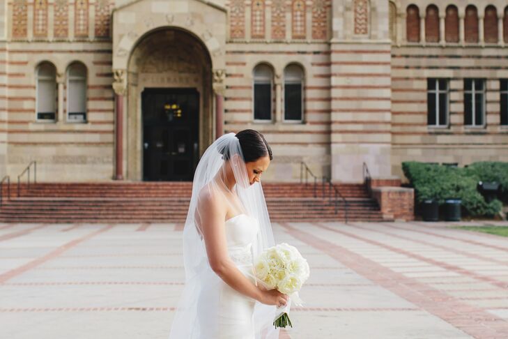 Madeline wore an ivory tulle veil with her updo hairstyle. She held an ivory garden rose bouquet.
