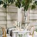 Reception Table With Ivory Linen, Wood Upholstered Chairs and Black Taper Candles