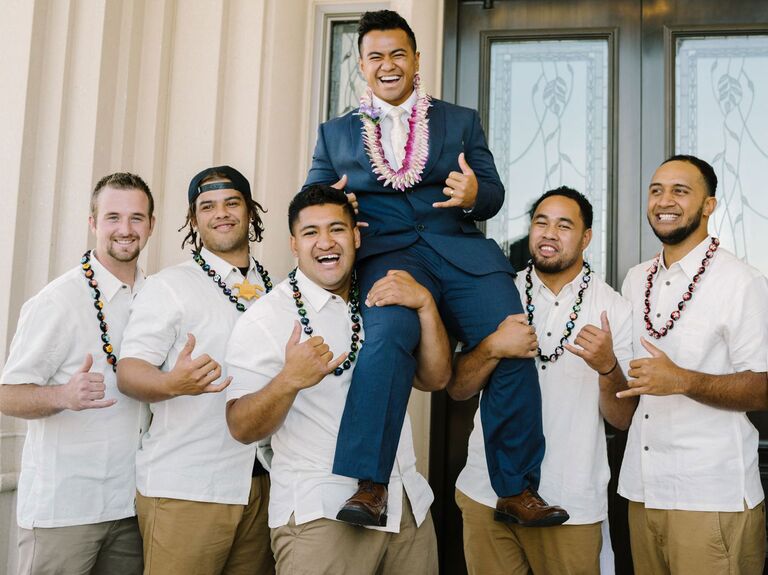 groomsmen in Polynesian clothing holding groom on their shoulders