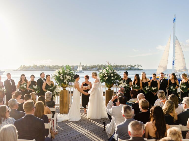 Brides exchanging vows on waterfront deck