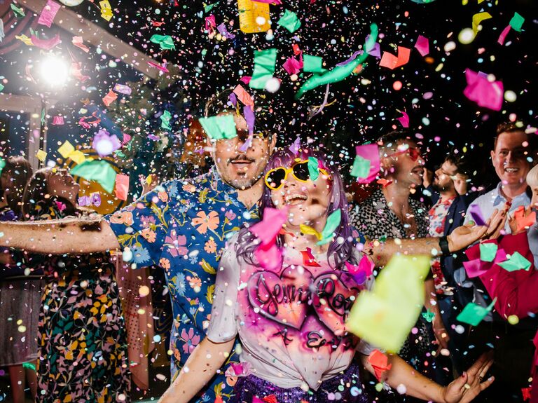 Couple dances while confetti falls around them. 