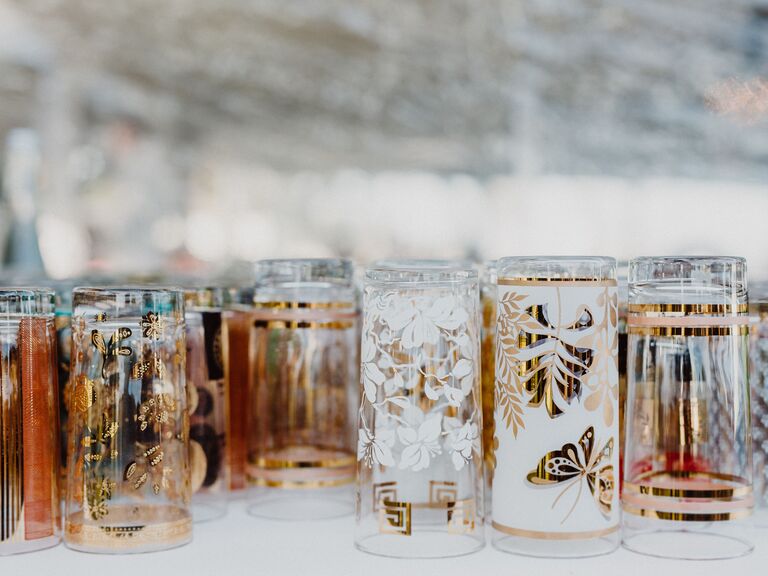 close up of vintage cocktail glasses decorated with gold, brown and white botanical prints and flowers 