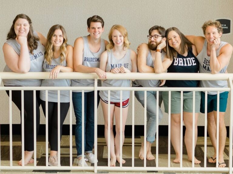 bride and wedding party posing in tank tops while getting ready