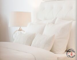 Comfy bed with white linens and pillows