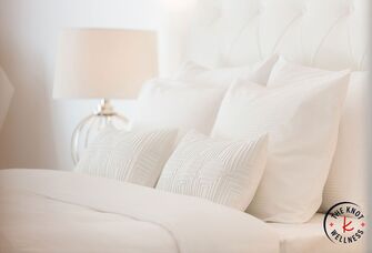 Comfy bed with white linens and pillows