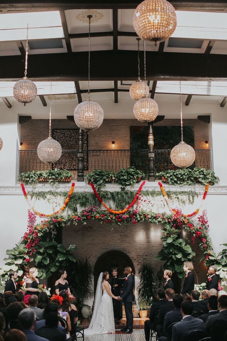 Glass orb chandeliers hanging about wedding ceremony