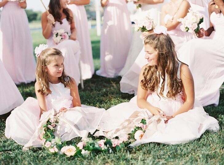 Flower girls wore white and pink organza dresses that were embellished with a flower at the waist. As they walked down the aisle, they carried a garland of fresh flowers rather than throw petals.