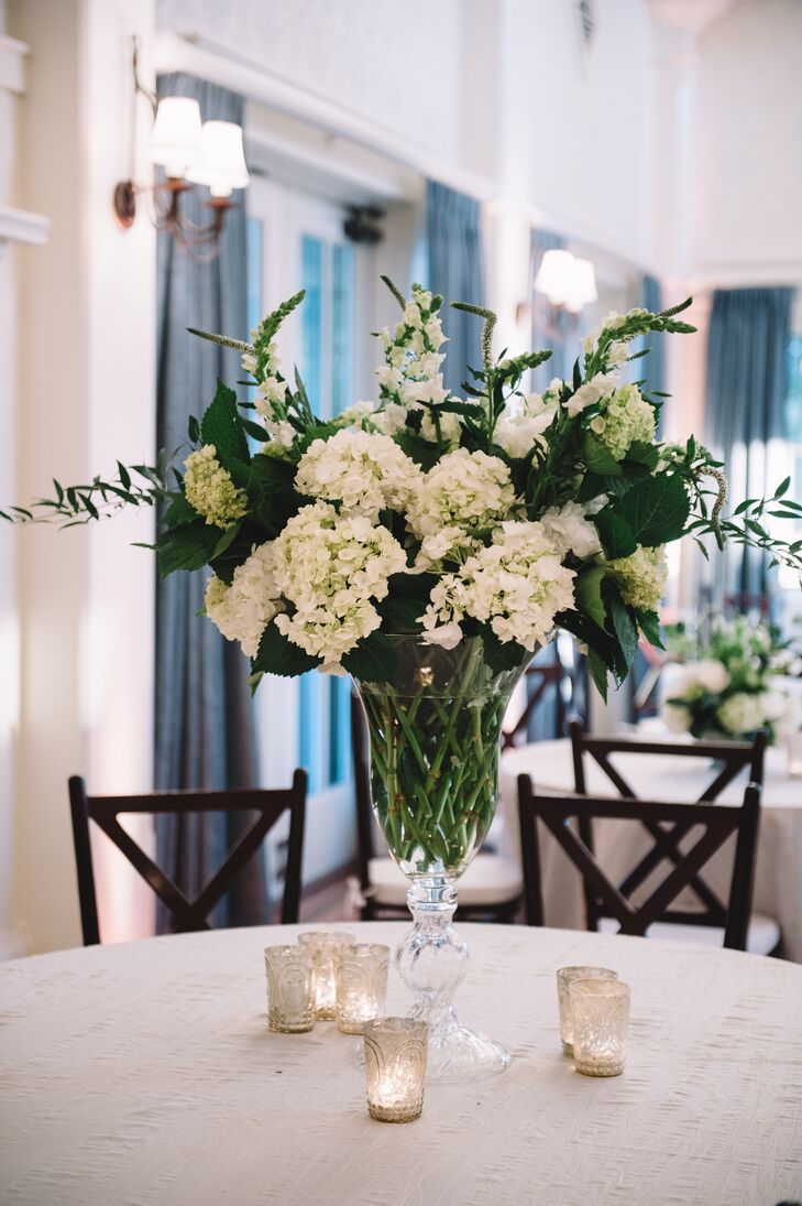 Florist Sue Burden crafted the simple greenery-rich centerpieces, which perfectly fit the white and green palette at The Inn at Pinebluff in Bluffton, South Carolina.