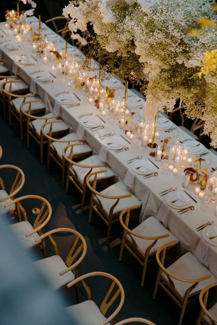 Long Reception Tables With Neutral Linens and Details, Many Candles Underneath Floral Installation
