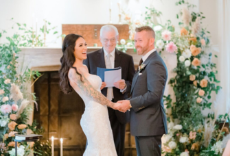 Bride and groom holding hands at the altar
