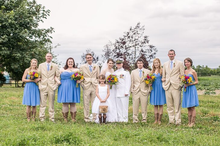 Justine and Josh stood with their wedding party outside at the venue. Bridesmaids wore cornflower-blue, strapless dresses with cowboy boots, while groomsmen sported tan suits with blue ties to match the bridesmaids.