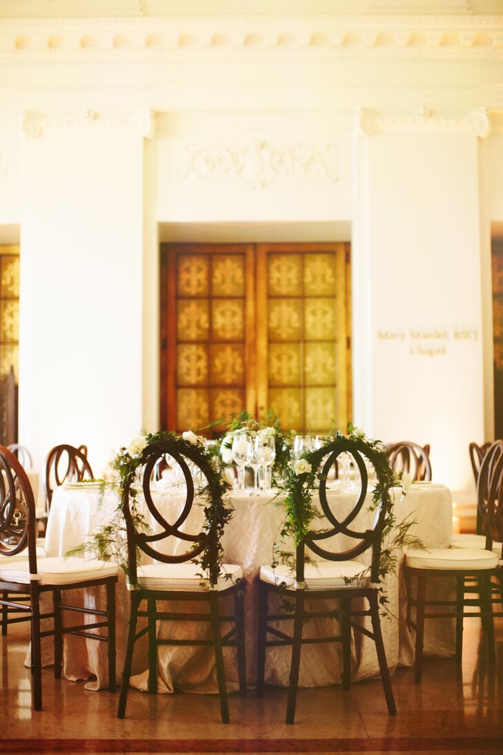 The wedding reception took place inside The James Leary Flood Mansion in San Francisco, California. Dining tables were simply dressed in white linens, and dark wooden chairs with white cushions surrounded the table. Hailey and Patrick had their chairs decorated in greenery to distinguish them from the rest.