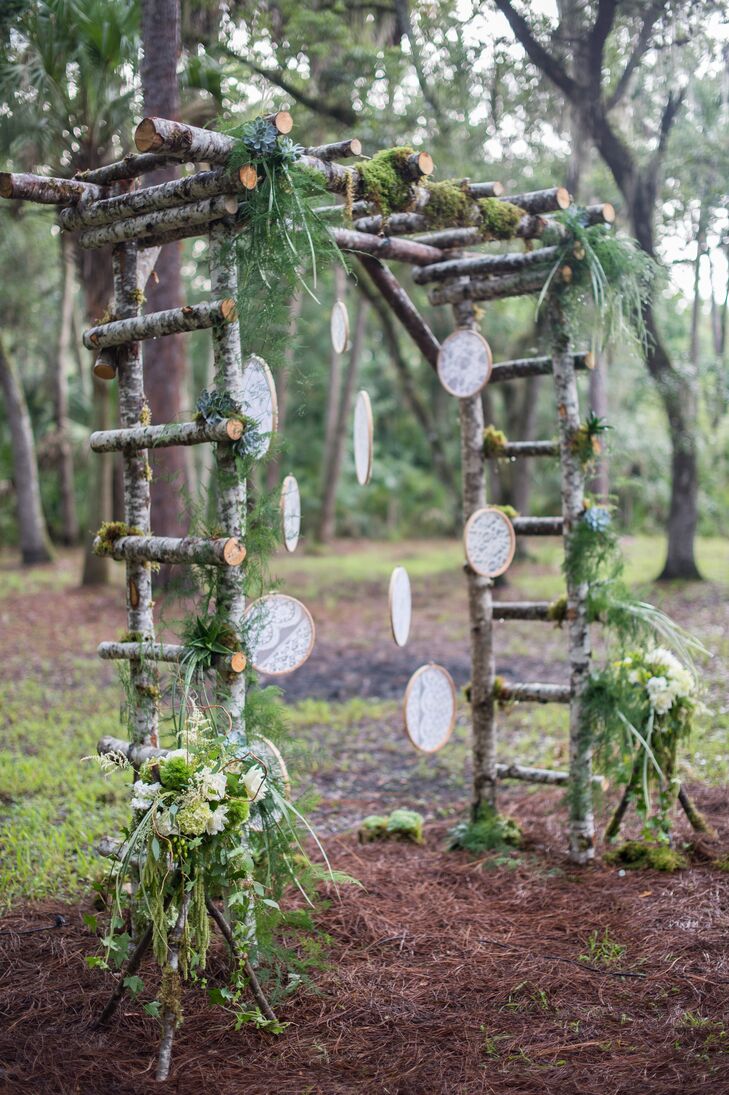 Tyler handcrafted the ceremony's birch wedding arch himself, adding a personal touch to the decor. Bunches of greenery and soft ivory flowers added a natural flourish to the piece, while hanging panels of lace added a vintage-inspired, whimsical note.