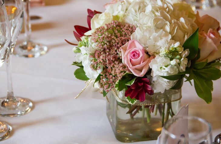 Dining tables dressed in white tablecloths were decorated with flower centerpieces filled with roses, hydrangeas, chrysanthemums and a variety of greenery.