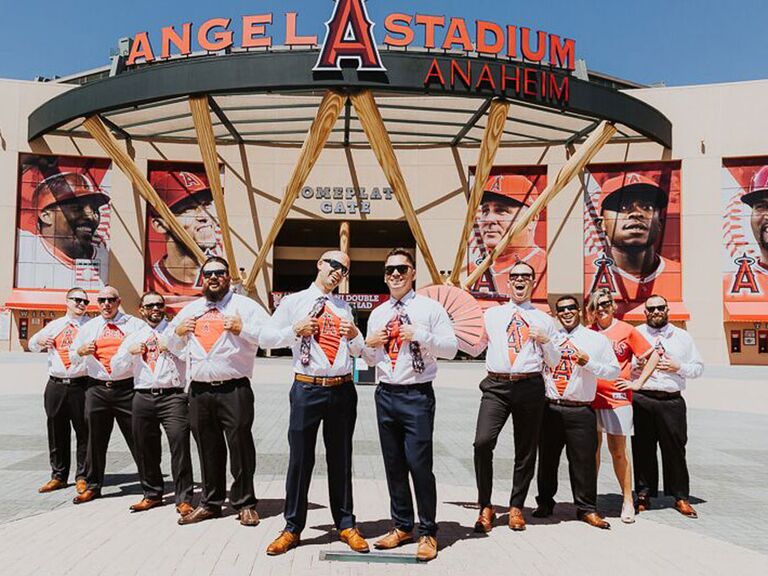 Groom and groomsmen showing off Los Angeles Angels undershirts in front of Angel Stadium