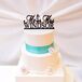 The white wedding cake had three round tiers and a square middle tier. The cake was decorated with white cake flowers and a fondant rope accent. It also featured turquoise ribbon accents and a nautical-themed cake topper.