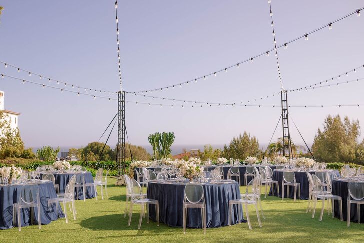 Reception With Blue Linens, Ghost Chairs and String Lights