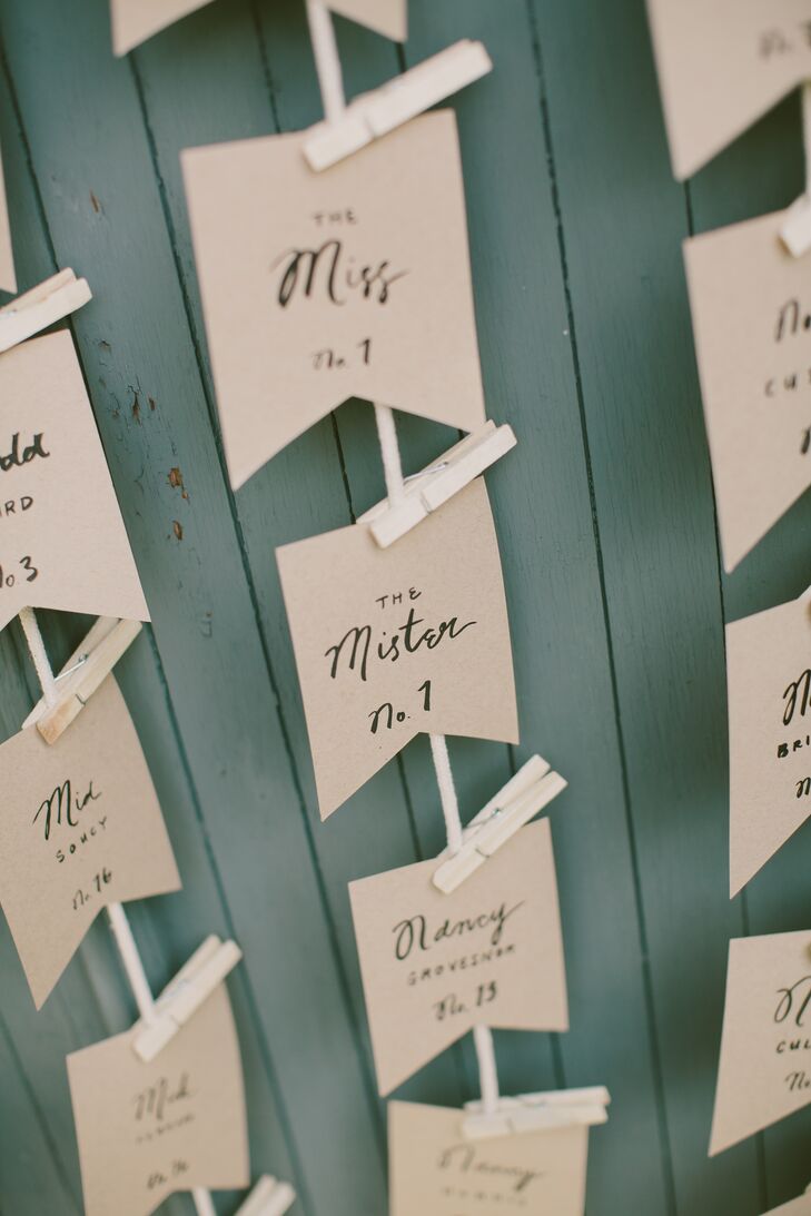 An amateur calligrapher, Erin created the escort cards for the reception in Newport, Rhode Island. She hand-lettered the names of each guest onto natural-colored pendant cards, which were then displayed against a wood-paneled barn door.