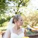 Britni's dress was an A-line Casablanca Bridal gown with straps and beading in the bodice. She accessorized with a pearl necklace and an embellished headband. She wore her hair in a chignon and paired her dress with an elbow-length veil for the ceremony.